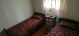 una camera da letto con due letti e una lampada su un tavolo di La Cañada a Colón