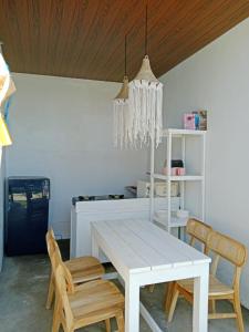 ein Esszimmer mit einem weißen Tisch und Stühlen in der Unterkunft Yuli Homestay in Uluwatu + 5 Fotos