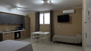 a small room with a bed and a table and a kitchen at Zia Lisa Home in CTA
