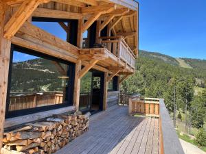 una baita con un ponte e una pila di tronchi di Chalet « Le 1712 » direct pistes a Les Angles