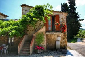 una casa de piedra con escaleras y una ventana con flores en Agriturismo Bellavista, en Radicondoli