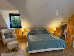 Un dormitorio con una cama, una silla y un espejo. en Chata Lada Repechy, en Bousín 115 fotos más
