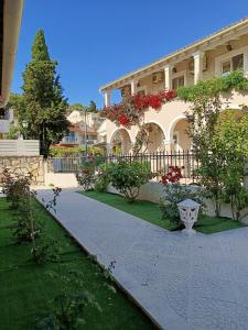 a large house with a fence and a walkway at Kalamionas Studios & Apartments in Kassiopi