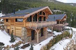 una baita di tronchi con un ponte avvolgente nella neve di Chalet 4 Saisons ski aux pieds a Les Angles