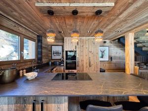 une cuisine avec des murs en bois et un grand comptoir dans l'établissement Chalet Colchiques aux pieds des pistes sauna, à Font-Romeu 17 autres photos