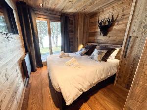 une chambre avec un lit dans une cabane en rondins dans l'établissement Chalet Colchiques aux pieds des pistes sauna, à Font-Romeu