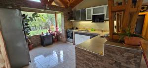 eine Küche mit weißen Geräten und einem großen Fenster in der Unterkunft Valkara Patagonia in Las Golondrinas