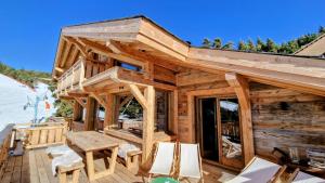 a log cabin with a table and chairs on a deck at Chalet Ski Bob pied de pistes jacuzzi in Font-Romeu