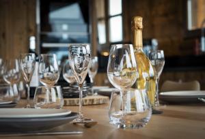 Una mesa con copas de vino y una botella de champán. en La Ferme de Charles vue jacuzzi sauna, en Bolquere Pyrenees 2000