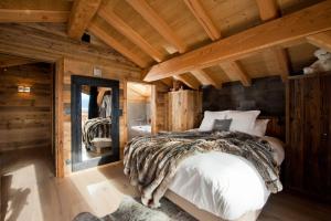 Un dormitorio con una cama en una cabaña de troncos en La Ferme de Charles vue jacuzzi sauna, en Bolquere Pyrenees 2000 17 fotos más