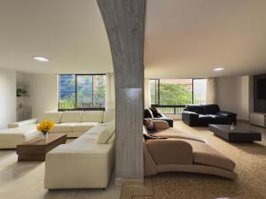 a living room with a white couch and a table at 4br 232 M Apartment In El Poblado, El Tesoro in Medellín