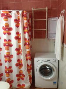 a bathroom with a washing machine and a shower curtain at Apartamento Muelle de Corralejo 14 in Corralejo