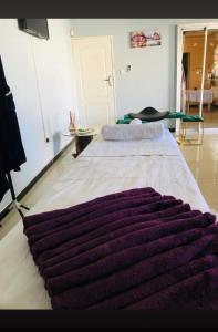 ein großes Bett mit einer lila Decke darüber in der Unterkunft Malebeswa Hillside View in Otse