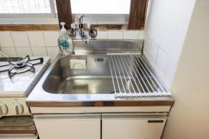 eine Edelstahlspüle in einer kleinen Küche in der Unterkunft GUEST HOUSE Hotori in Ōtsu + 24 Fotos