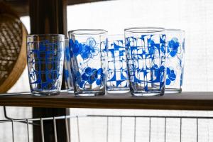 vier blau-weiße Gläser auf einem Regal in der Unterkunft GUEST HOUSE Hotori in Ōtsu