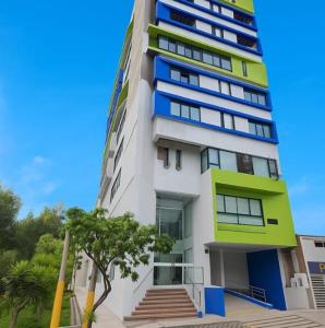 a tall white building with blue and green windows at Edificio Sky Tower in Arequipa