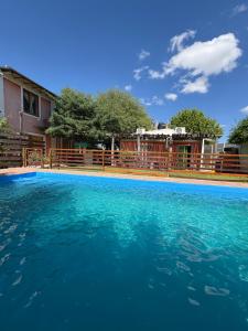 a large pool of blue water in front of a house at Cabañas Las Marias in San Luis