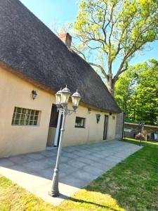 une maison avec un lampadaire devant dans l'établissement La Chaumière de Lilou, Havre de paix en campagne, à Merckeghem