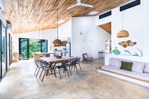 a dining room with a table and chairs and a couch at Private rainforest villa up to 8 guests w jacuzzi near Rio Celeste in Upala