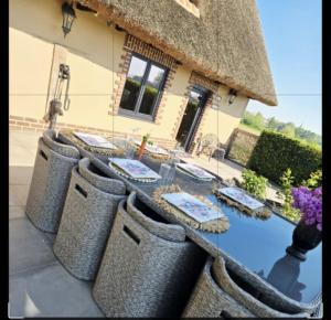 une table devant une maison avec des chaises dans l'établissement La Chaumière de Lilou, Havre de paix en campagne, à Merckeghem