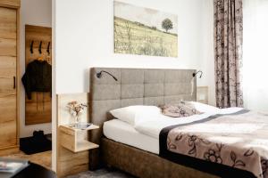 a bedroom with a bed with a headboard at Hotel Goisererhof in Bad Goisern +37 photos