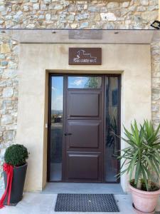 a brown door to a building with a sign above it at Pedro Country House in Canossa