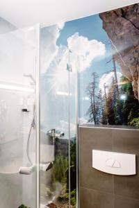 a bathroom with a shower with a painting on the wall at Hotel Goisererhof in Bad Goisern