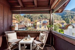 a balcony with two chairs and a table and a view at Villa Gartenblick in Kufstein