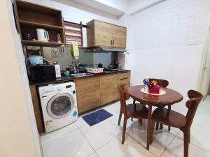 eine Küche mit einem Tisch und einer Waschmaschine in der Unterkunft Timurbay Residence RY in Kampung Sungai Karang