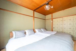 ein Schlafzimmer mit zwei Betten mit weißen Kissen in der Unterkunft GUEST HOUSE Hotori in Ōtsu