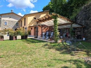 a house with a pergola and a table and chairs at Pedro Country House in Canossa