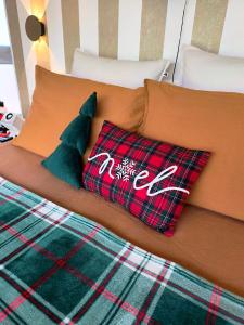a bed with two plaid pillows on it at Dôme Saint-Eloi in Floursies