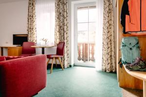 a living room with a red couch and a window at Hotel - Restaurant Goisererhof 3S in Bad Goisern