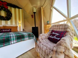 a bedroom with a bed and a chair with a pillow at Dôme Saint-Eloi in Floursies