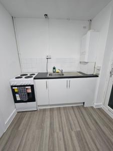 eine weiße Küche mit Spüle und Herd in der Unterkunft Coral Bay Seaside Aparto in Clacton-on-Sea