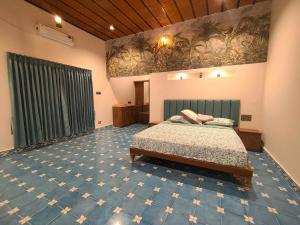 PerūrMithalai Farm by Palette I 4BHK I Kids's Play I Coimbatore的一间卧室配有一张床,铺有蓝色地毯