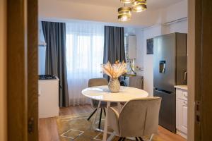 a kitchen with a table with chairs and a refrigerator at Apartament de închiriat Accommodation nr 12 in Suceava