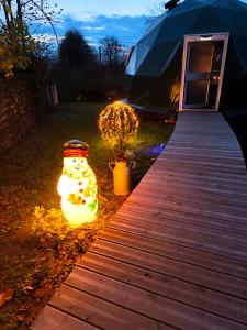 a tent with christmas lights next to a wooden walkway at Dôme Saint-Eloi in Floursies +15 photos