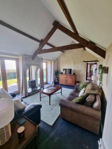 a living room with a couch and a table at The Piggery - North Wales Retreat - Wilde Retreats in Pwllheli
