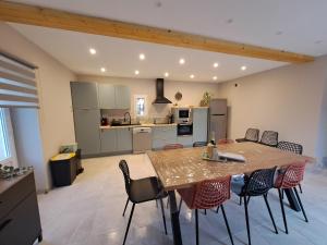 a kitchen and dining room with a table and chairs at Le Gîte du Pêcheur, en campagne pour 10 personnes, Piscine privée et jardin in Damazan