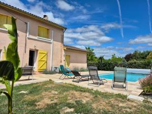 a patio with chairs and a swimming pool at Le Gîte du Pêcheur, en campagne pour 10 personnes, Piscine privée et jardin in Damazan