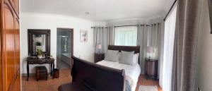 a bedroom with a bed with white sheets and a window at The Hops Inn in George +104 photos