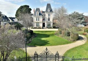 une image d'une grande maison avec un portail dans l'établissement La Plage du Petit Port, à Cancale