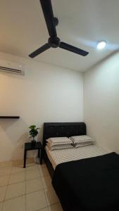 a bedroom with a black bed and a ceiling fan at Ayana Homestay in Tawau