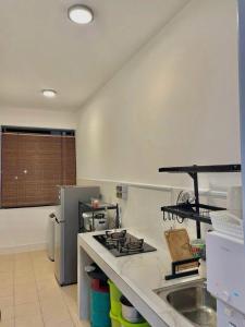 a kitchen with a sink and a stove top oven at Ayana Homestay in Tawau