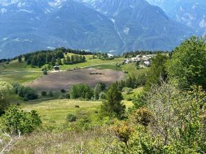 a green field with trees and mountains in the background at Casa Luigina in Verrayes