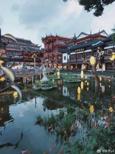 a pond with a fountain in front of a building at Jinglai Hotel Bushe - Shanghai Nanjing East Road Bund Branch in Shanghai