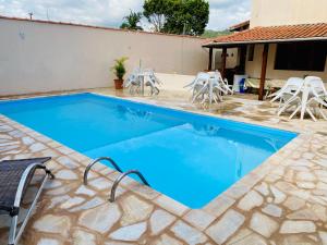 a swimming pool with chairs and a table at Casa Família Silva próximo ao Santuário Nacional in Aparecida