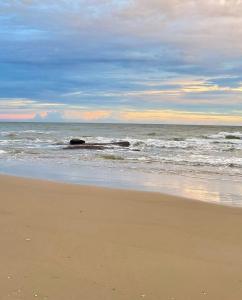 a beach with waves and rocks in the ocean at A Day Rayong in Ban Pa Khan