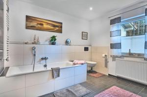 a bathroom with a tub and a sink and a toilet at Ferienwohnungen Geiger in Bodenmais +41 photos
